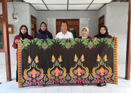 Penyerahan batik dari mahasiswa kepada Kepala Desa